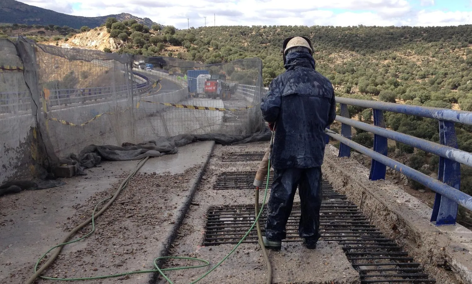 Operario de Hidrodem haciendo hidrodemolición manual sobre el borde de un tablero de puente